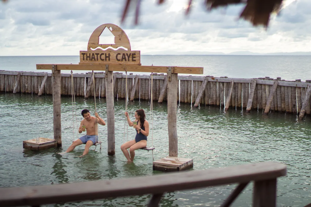 Couple swinging at Thatch Caye Resort