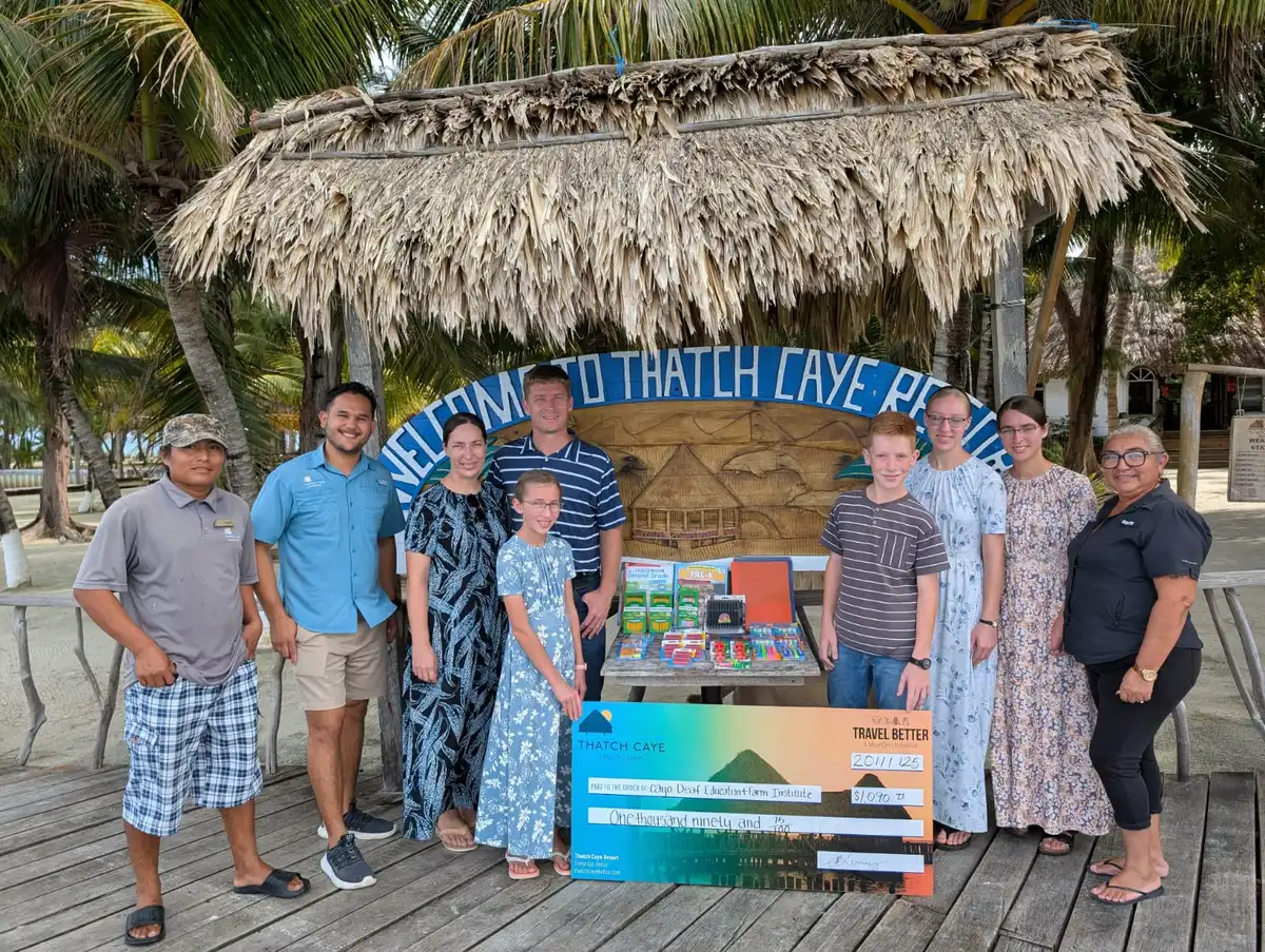 Thatch Caye guests presenting philanthropy donation Pack for a Purpose supplies | MuyOno Resorts